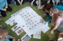 Dzieci na dywanie rozwiązują krzyżówkę - hasło ekologia