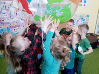 Dzieci z grupy VIII podczas zabawy z piłką w kształcie kuli ziemskiej.