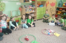 Dzieci na dywanie układają elementy przyrodnicze