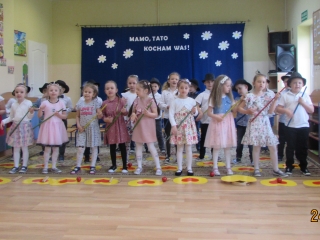 Dzieci z gr. V spiewaja piosenke dla Taty imitujac laskami gre na gitarze.