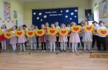 Dzieci z grupy V z duzymi sercami w dłoniach spiewaja piosenke dla Mamy.