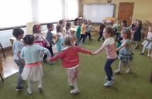 Dzieci tancza w kole przy muzyce z dzieciecego repertuaru