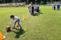 Dzieci pokonuja tor przeszkod z pilka