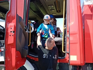 Dzieci z grupy VIII zwiedzaja woz strazacki.