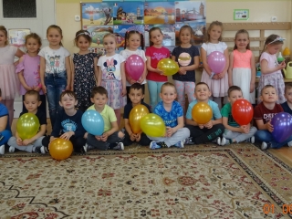 Usmiechniete pieciolatki pozuja grupowo z balonami.