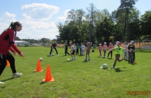 Dzieci piecioletnie z grupy V celuja pilkami do bramek.