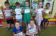 Przedszkolaki z pokolorowanymi kartami pracy