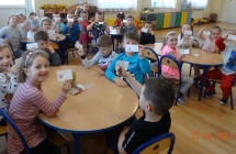 Usmiechniete pieciolatki z gr. V prezentuja pokolorowane karty Jak dbac o nature.