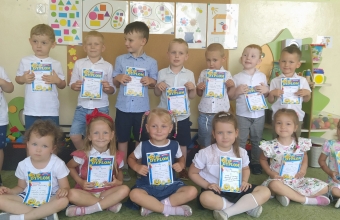 dzieci trzymaja dyplomy