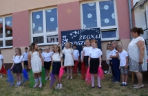 Dziewczynki z kolorowymi chustami w dloni stoja ustawione w dwoch rzedach do tanca