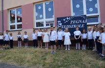 dzieci ustawione w polkolu, chlopiec na srodku mowi wiersz