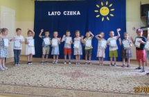 Dzieci z gr. V  z dyplomami wesolo machaja na zakonczenie.