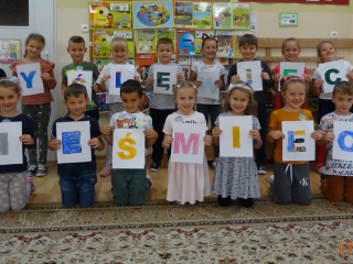 Usmiechniete dzieci z gr. VII z literami tworzacymi haslo Mysle, wiec nie smiece