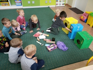 Dziecko wrzuca papierowe smieci do kosza (2)