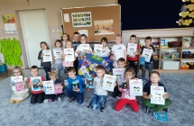 Dzieci z upominkami, dyplomami i odznakami