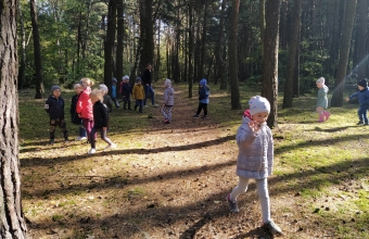 dzieci spaceruja po lesie