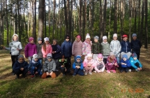 Radosne dzieci z gr. VII na tle lasu.