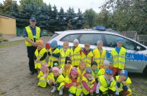 Grupa V z policjantem przed radiowozem