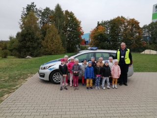 Zdjecie przed radiowozem - dzieci z grupy VI z policjantem