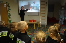 Sześciolatki oglądają film na ekranie tablicy multimefialnej.