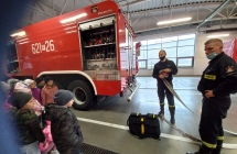 Strażacy prezentują obsługę węża gaśniczego. 