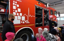 Strażacy pokazują dzieciom wóz bojowy. 