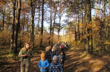 Dzieci sluchaja opowiadania przewodniczki podczas wycieczki