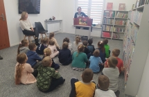 Sześciolatki z gr. VII słuchają baśni prezentowanej przez p. bibliotekarkę w teatrzyku kamishibai.