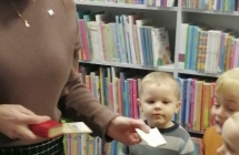 Dzieci ogladaja najmniejsza ksiazke ze zbioru bibliotecznego