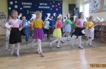 Sześciolatki w układzie tanecznym z papierowymi ptakami.