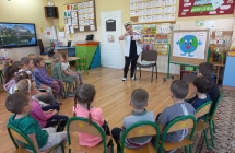 Pielegniarka demonstruje na modelu zębów technikę ich szczotkowania. 