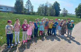 Dzieci z gr. VII dmuchaja dmuchawce.