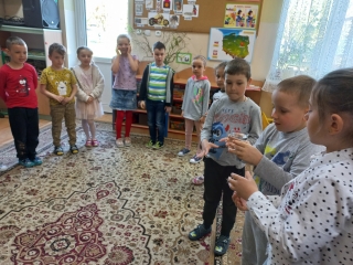 Dzieci z gr. VII przekazują sobie szklankę wypelnioną wodą.