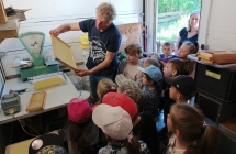 dzieci przygladaja sie pracy pszczelarza