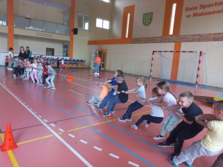 Dz. z gr. VII przeciagają linę na hali sportowej.