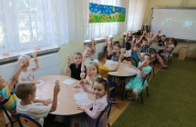 Przedszkolaki przy stolikach jedza lody