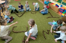 Dzieci ukladaja litery z materialu przyrodniczego