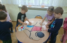 Dzieci maluja farbami auta z kartonu