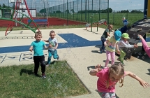 Dzieci na boisku puszczaja banki mydlane.