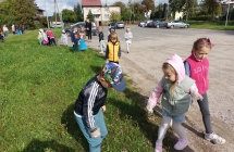 Dzieci sprzataja teren przy przedszkolu