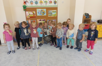 Usmiechniete maluszki z workiem zebranych odpadow.