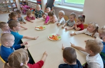 Dzieci z gr. I przy stoliku z pokrojonymi warzywami.