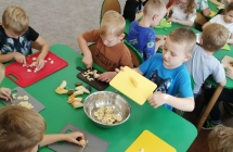 Chlopiec zsypuje owoce do miski