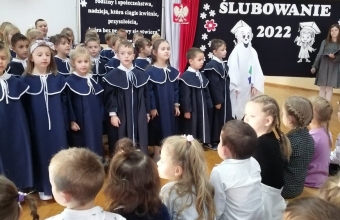 Dzieci stoja w towarzystwie szkolnego duszka