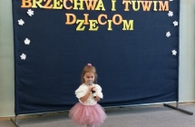 Dziewczynka w rozowej spodniczce recytuje wiersz