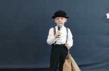 Chlopiec w kapeluszu recytuje wiersz