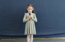 Dziewczynka w zielonej sukience recytuje wiersz