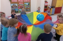 Radosne dzieci z gr. I podczas zabawy z chusta i balonami. 