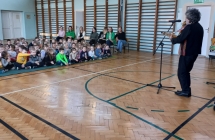 Mężczyzna grający na instrumencie dla dzieci w szkolnym holu 