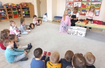 Maluszki obserwuja jak pani fryzjerka zaplata warkocz.